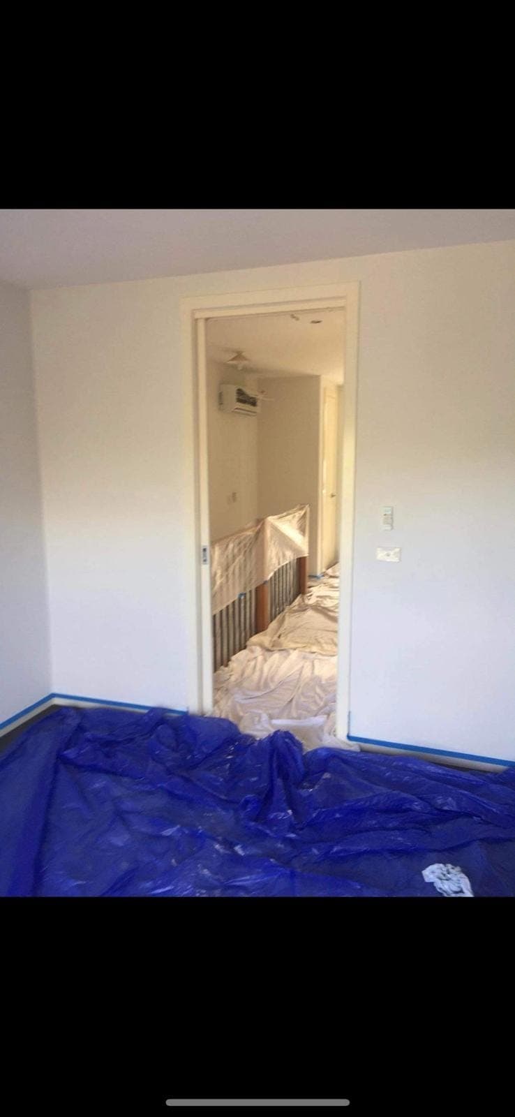 Renovation photo: hallway with protective floor covering during painting