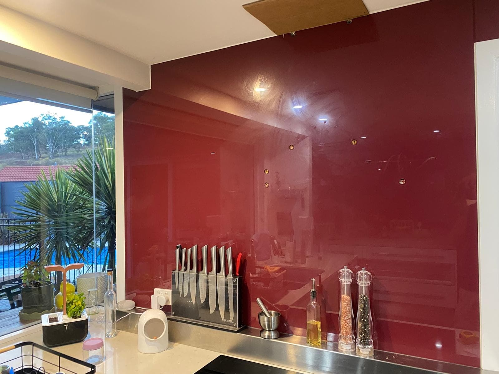 Renovation photo: kitchen with red glass splashback installed