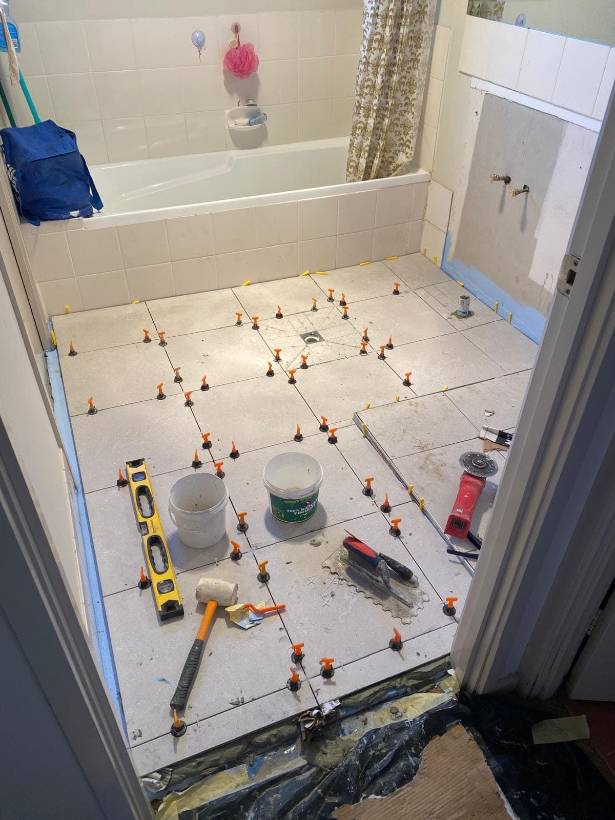 Renovation photo: bathroom floor with tile leveling spacers