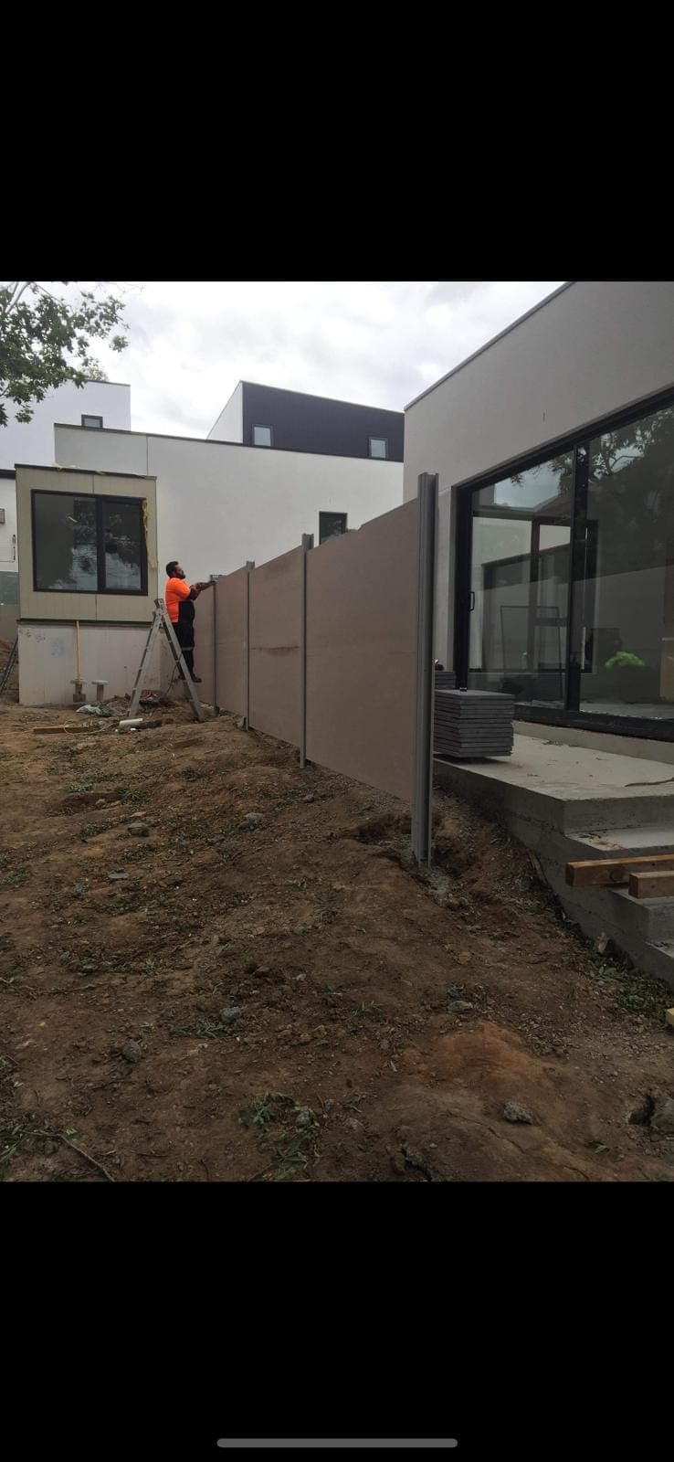 Renovation photo: worker installing fence panels outdoors