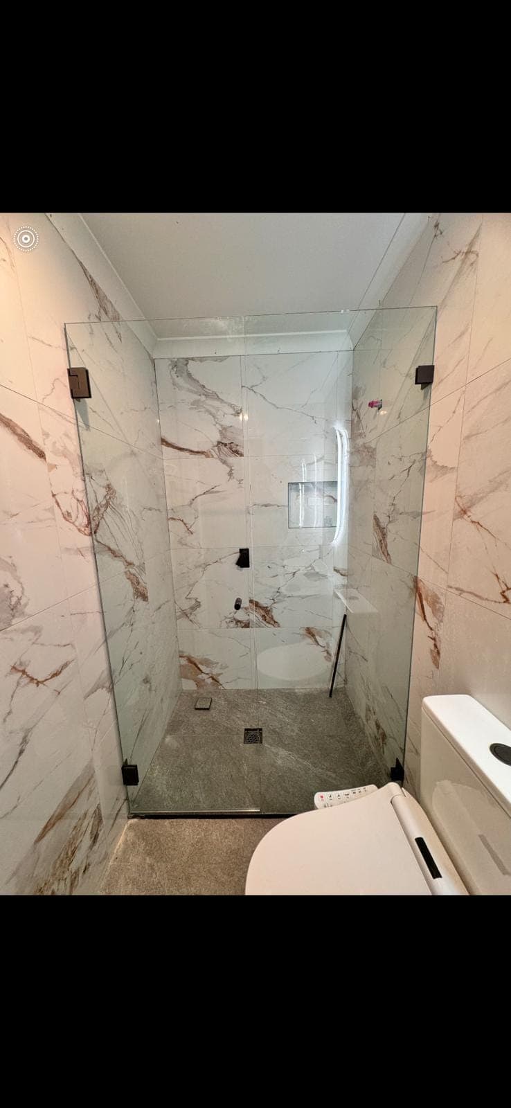 Renovation photo: marble look tiled shower with frameless screen