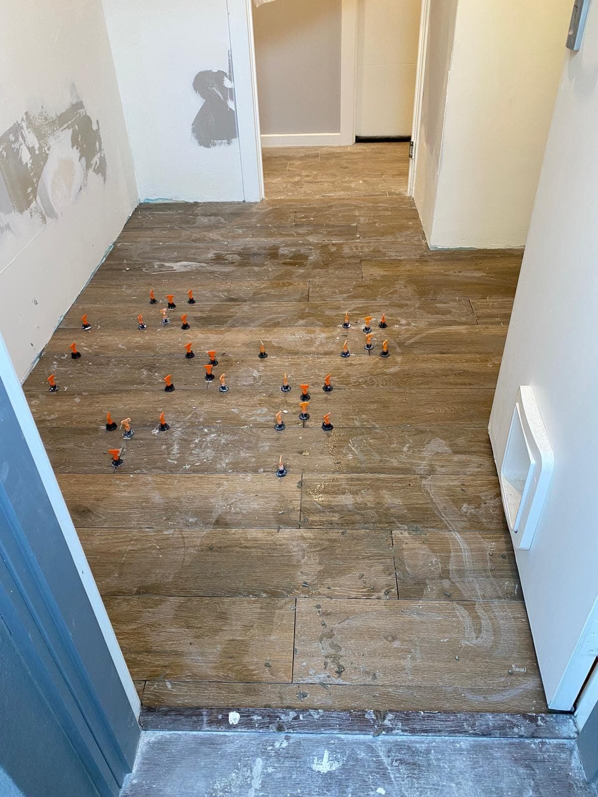 Renovation photo: wood look floor tiles with leveling spacers